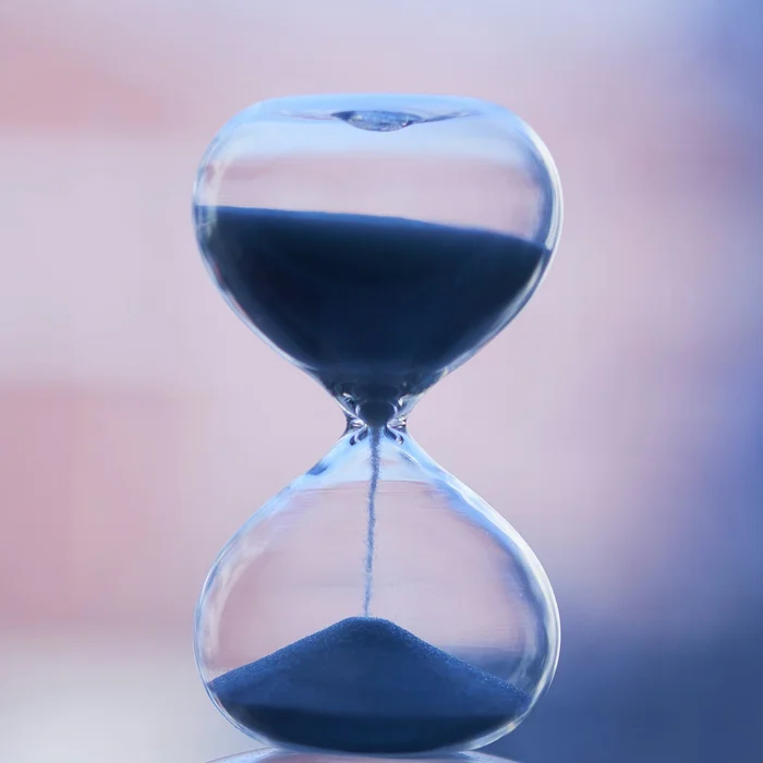 An hourglass with sand running through it, representing the mandatory timing of Required Minimum Distributions
