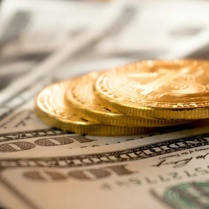 Gold coins stacked on cash, representing a deliberate order of withdrawing retirement income